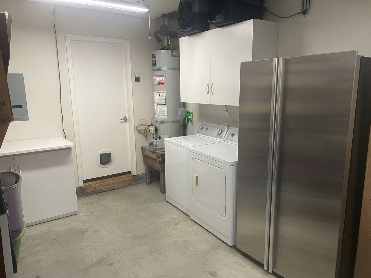 Washer, dryer, water heater, and a stainless refrigerator in the garage