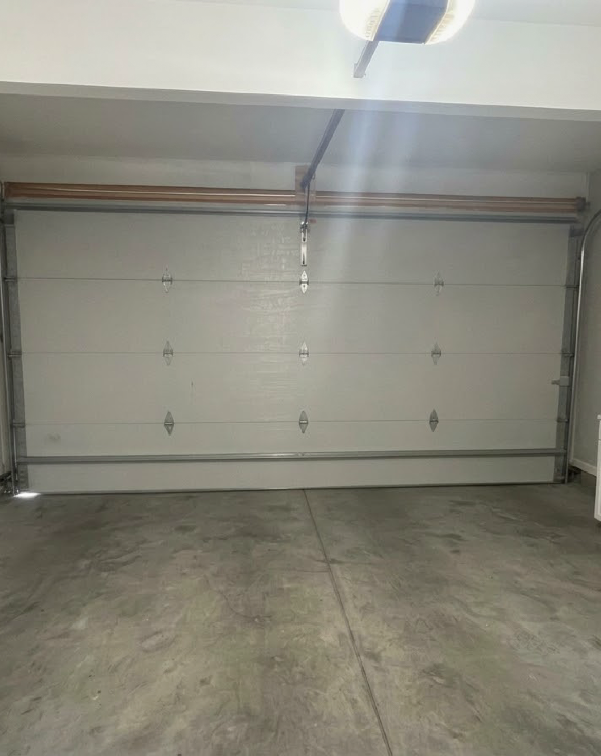 Interior of a two-car garage, facing a white sectional garage door