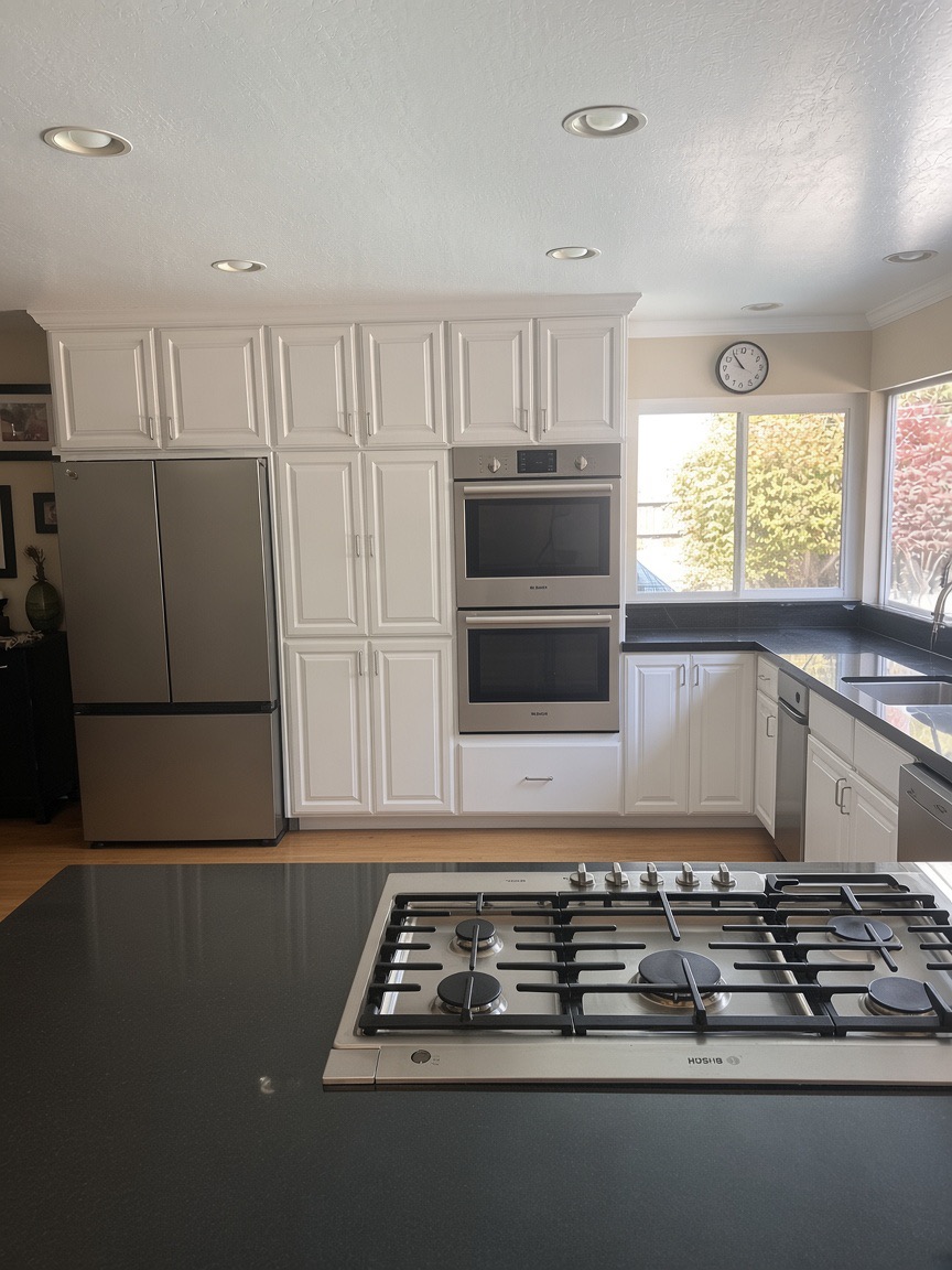 Kitchen island with a five-burner gas cooktop, a stainless double wall oven, and a refrigerator