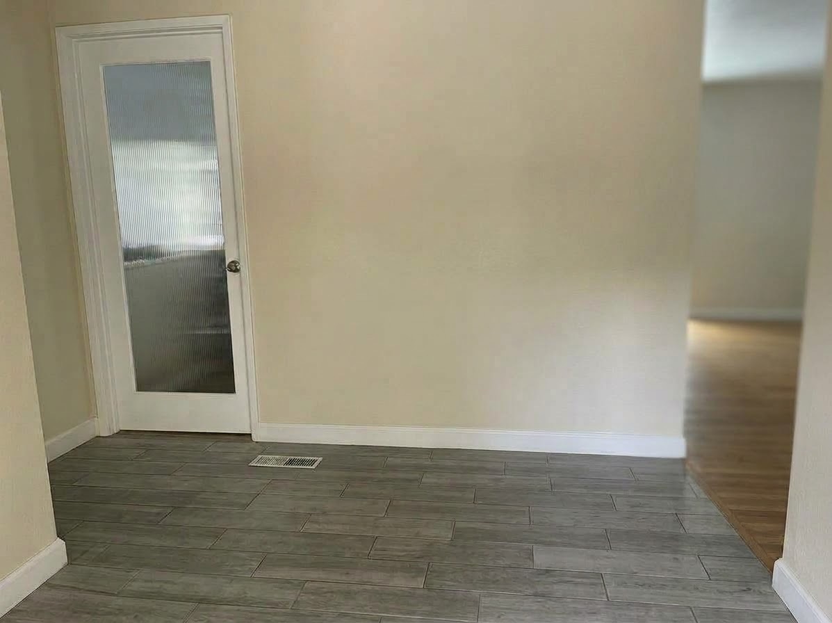 A white door with a frosted glass panel, just off the tiled entry